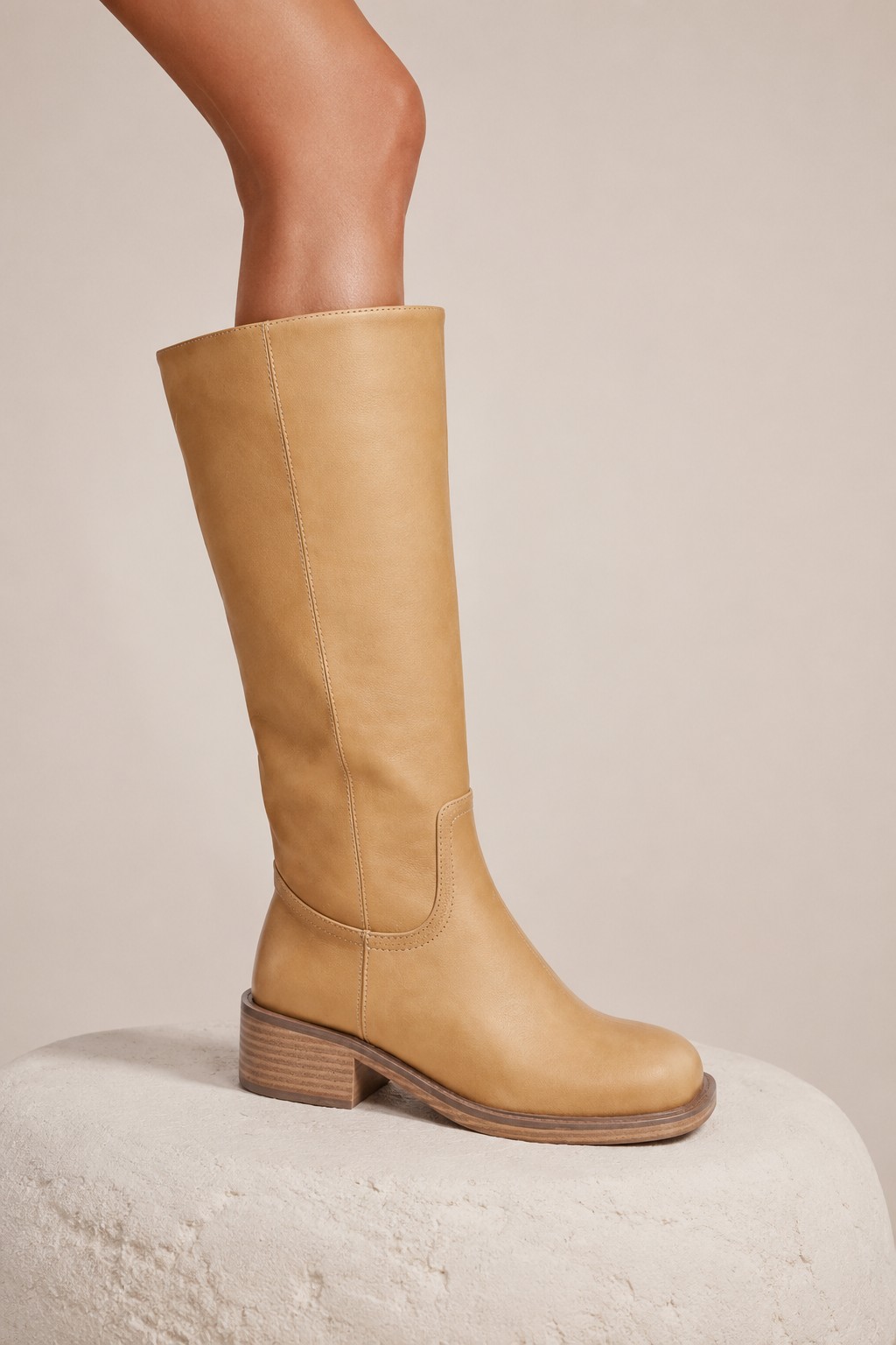 Tan leather knee-high riding boot with stacked heel