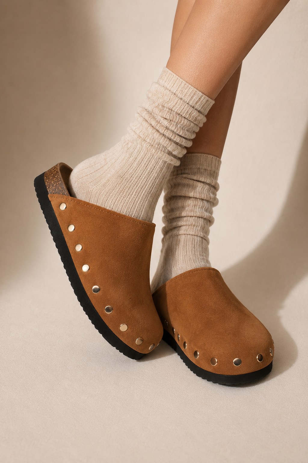 Tan suede studded clog mule worn with cream slouch socks
